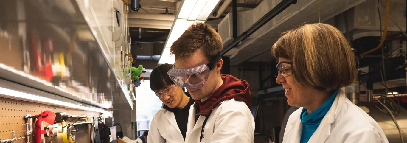 students and professor working in lab