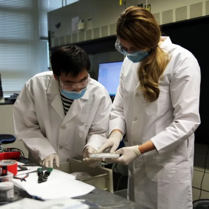 Daugs (right) and graduate student Jiang Luo conduct scientific research in the lab of Bryce Sadtler, assistant professor of chemistry.